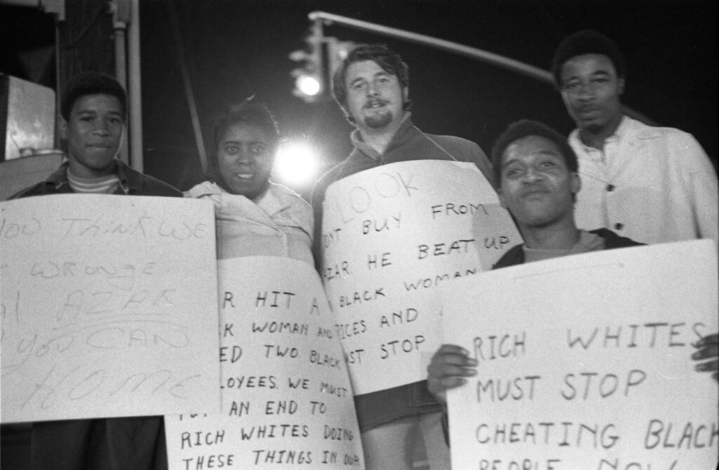 Black and white photograph of a group of people holding protest signs