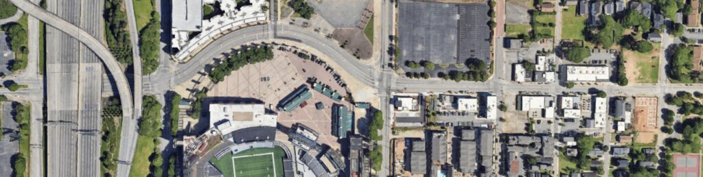 Aerial color photograph showing curve of Georgia Avenue above a section of parking lot and stadium.