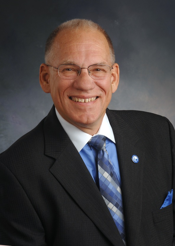 Color portrait of a smiling white man wearing a suit and tie